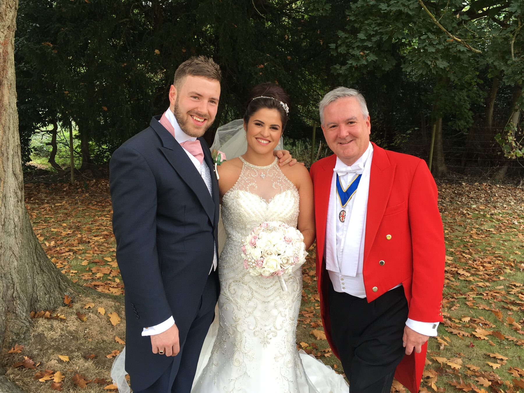 Andrew Morgan with a bride and groom under trees at their wedding
